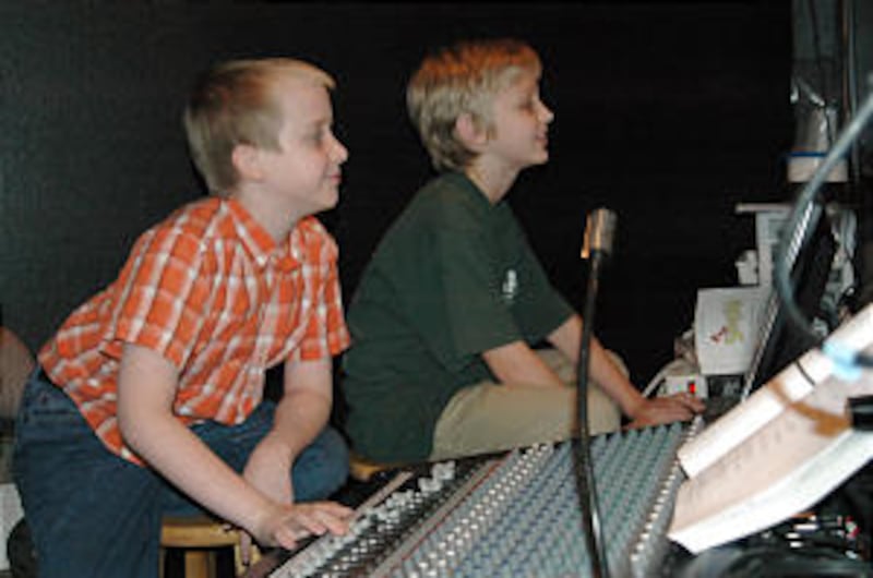 Nine-year-old Ryan Siler, left, and 10-year-old Cameron Barrus work the lights and sound board durin