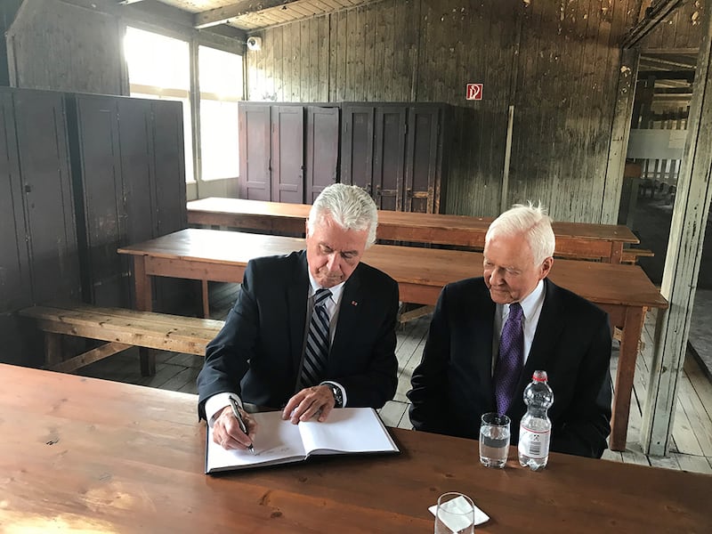 Elder Dieter F. Uchtdorf of the Quorum of the Twelve Apostles and U.S. Sen. Orrin Hatch of Utah sign a guest book while sitting in one of the prisoner barracks of the Sachsenhausen concentration camp in Oranienburg, Germany, July 5, 2018.