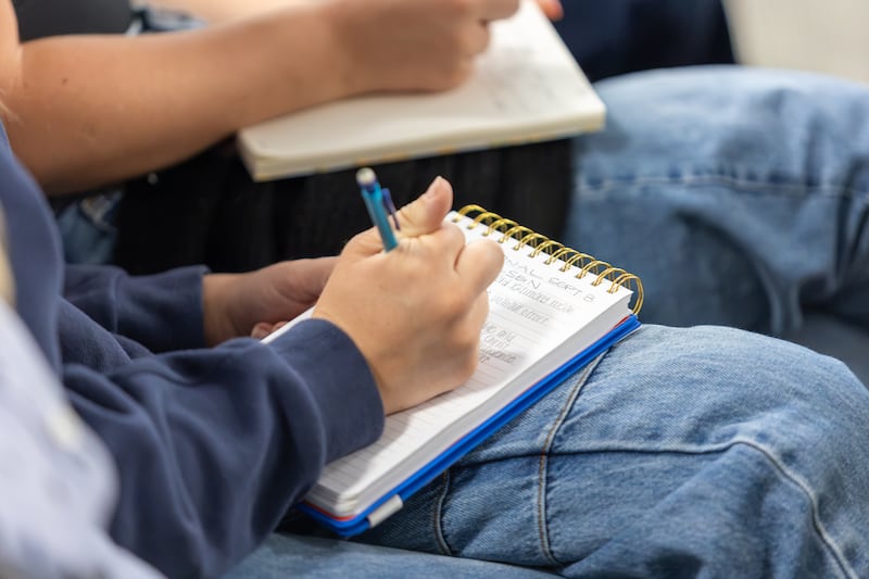 Students take notes as Deseret News publisher Burke Olsen speaks during an Ensign College devotional in Salt Lake City, Sept. 8, 2026.