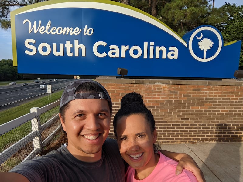 Vanessa Duerson and her husband, Brian Kristofer Duerson, take a selfie in front of the South Carolina welcome sign at the South Carolina Welcome Center in Fort Mill, South Carolina, on June 30, 2022.