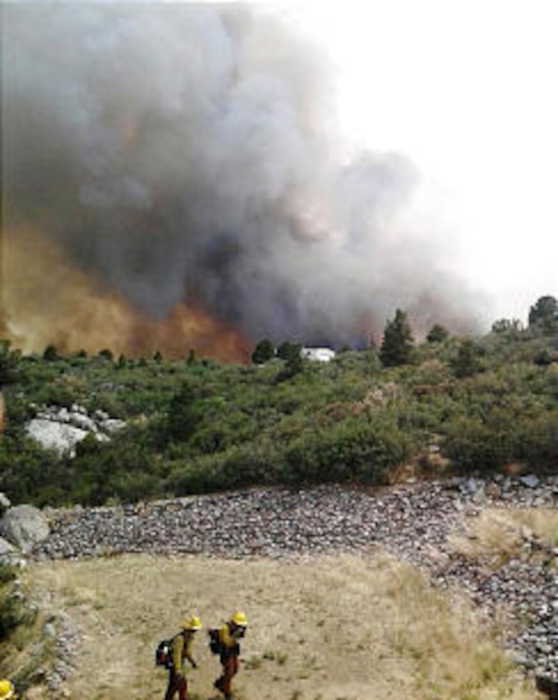 Firefighters work near a wildfire burning along a ridge in Yarnell, Ariz., in this photo provided by