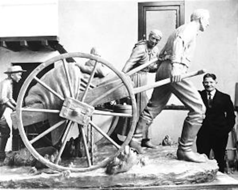 Torleif Knaphus is shown with "Handcart Pioneers" sculpture he designed, which eventually became a f