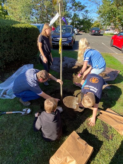 Allan Broadbent and children plant a tree in Fairfield County, Connecticut.