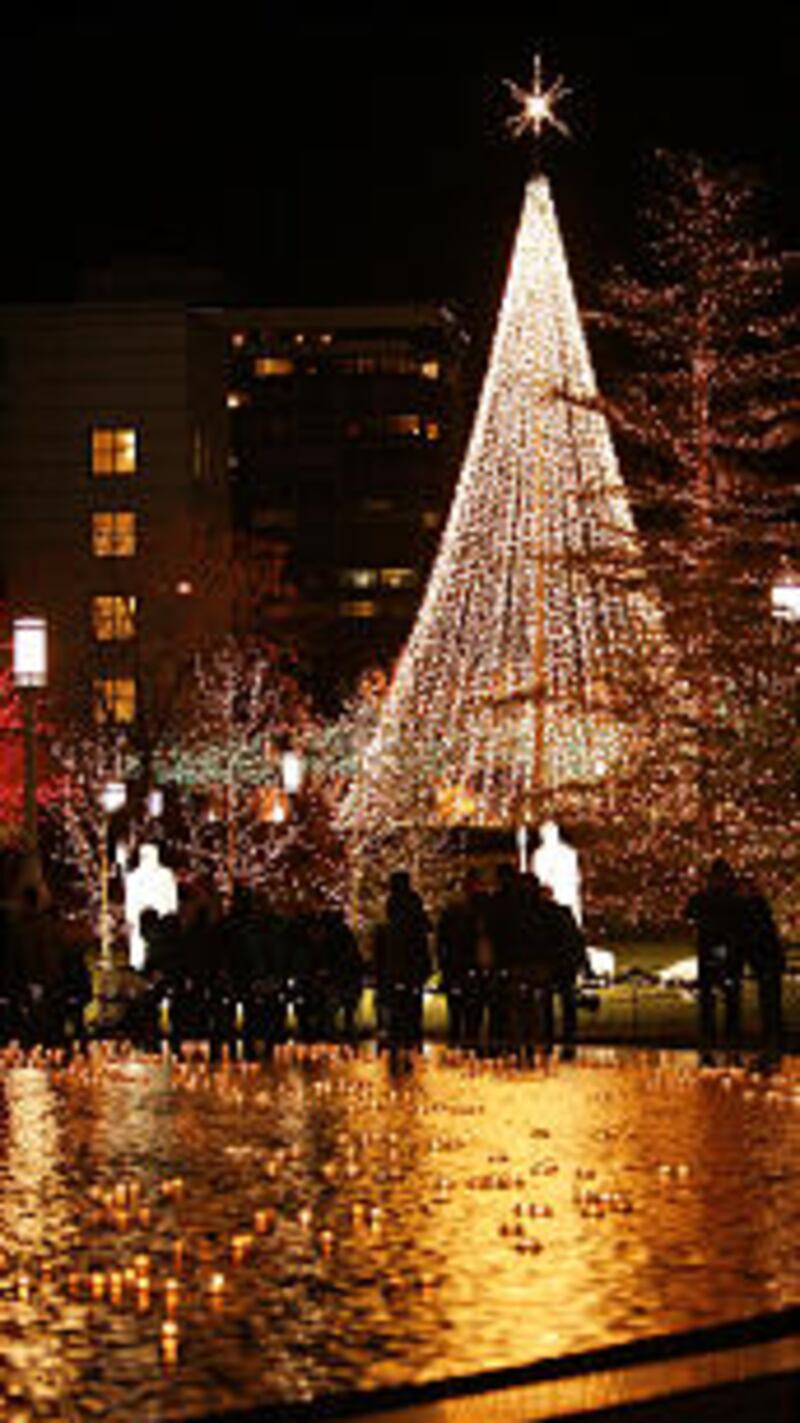Downtown visitors walk through the Main Street Plaza as Christmas lights are turned on downtown an