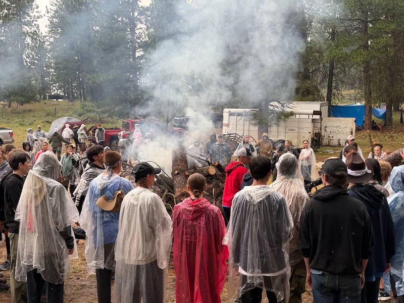 Spokane Valley Washington Stake youth stand around a bonfire in Bend, Idaho, during a trek June 26, 2026.