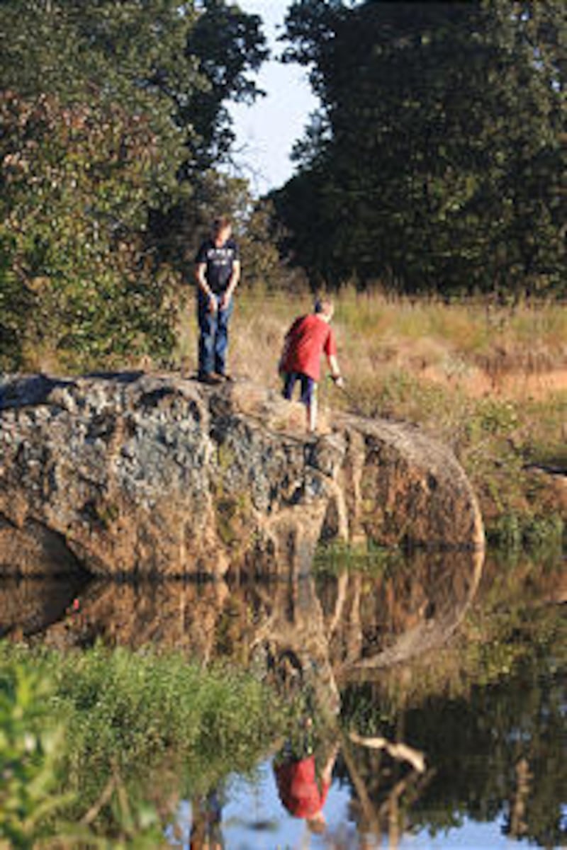 Two young men enjoy fishing while at camp commemorating 100 years of the Church's affiliation with t