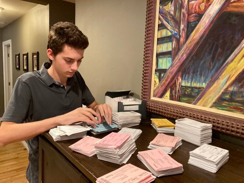 Luke Morrison, 16, organizes temple ordinance cards he has found by doing family history research.