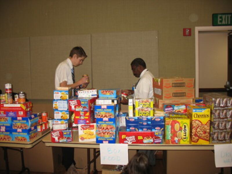 Volunteers sort and prepare food to be boxed.