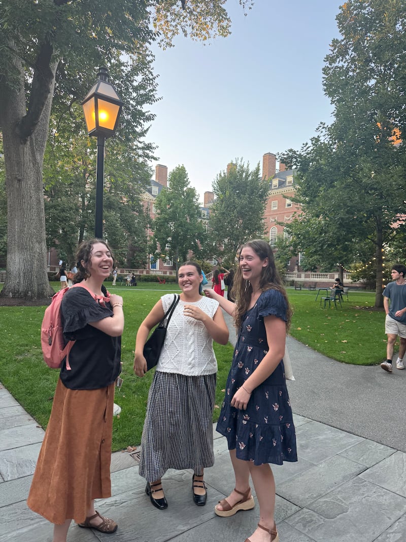 Rachel Hunter, Chloe Call and Elise Jarvis laugh together on the campus of Harvard University in Cambridge, Massachusetts, Sept. 28, 2025.