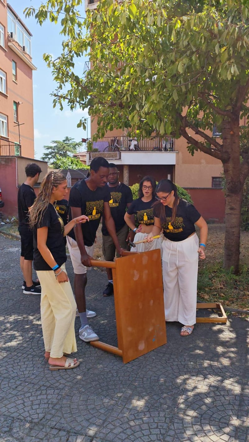 Young single adults work together to dismantle furniture during a service project at Casa Scalabrini 634 in Rome, Italy.