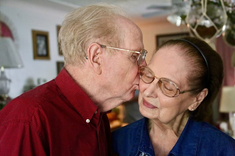 Elden Wood kisses the cheek of his wife, Picola Wood, at their home. Together they have served six Latter-day Saint missions.