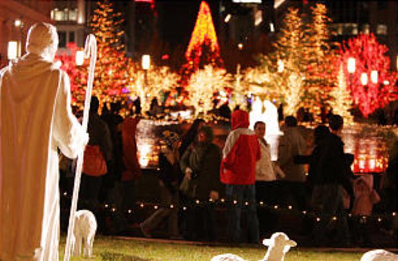 Downtown visitors walk through the Main Street Plaza as Christmas lights are turned on downtown an