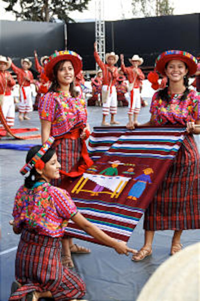 Young women don the colorful and traditional clothing of western Guatemala for a popular folk dance.