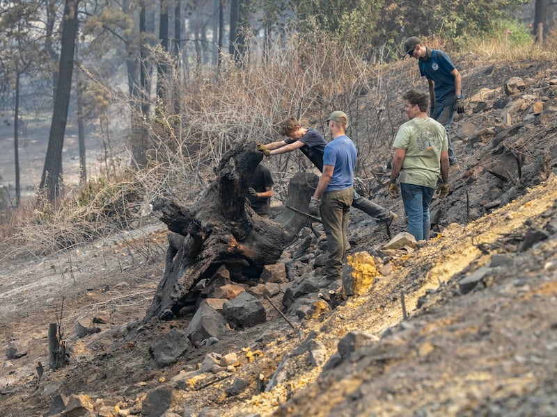 Young men and leaders from the Spokane Washington Mount Spokane Stake help clear debris from a neighborhood damaged by wildfires in Spokane, Washington, on Monday, Aug. 3, 2026.