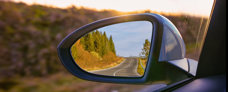 The view of the mountains in a car's side mirror.