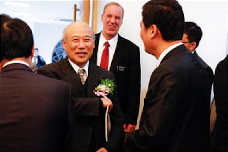 Catholic Father YongHae Kim greets Elder ChangHo Kim, area seventy, Nov. 18, 2012.