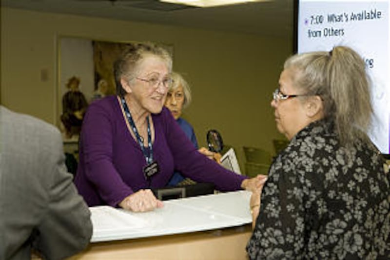 Sister Carol Hughes, a Los Angeles Family History Library volunteer, assists a visitor.