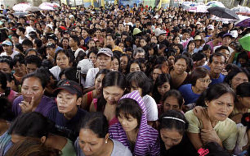 Flood affected residents gather for relief goods in suburban Marikina, east of Manila, Philippines o