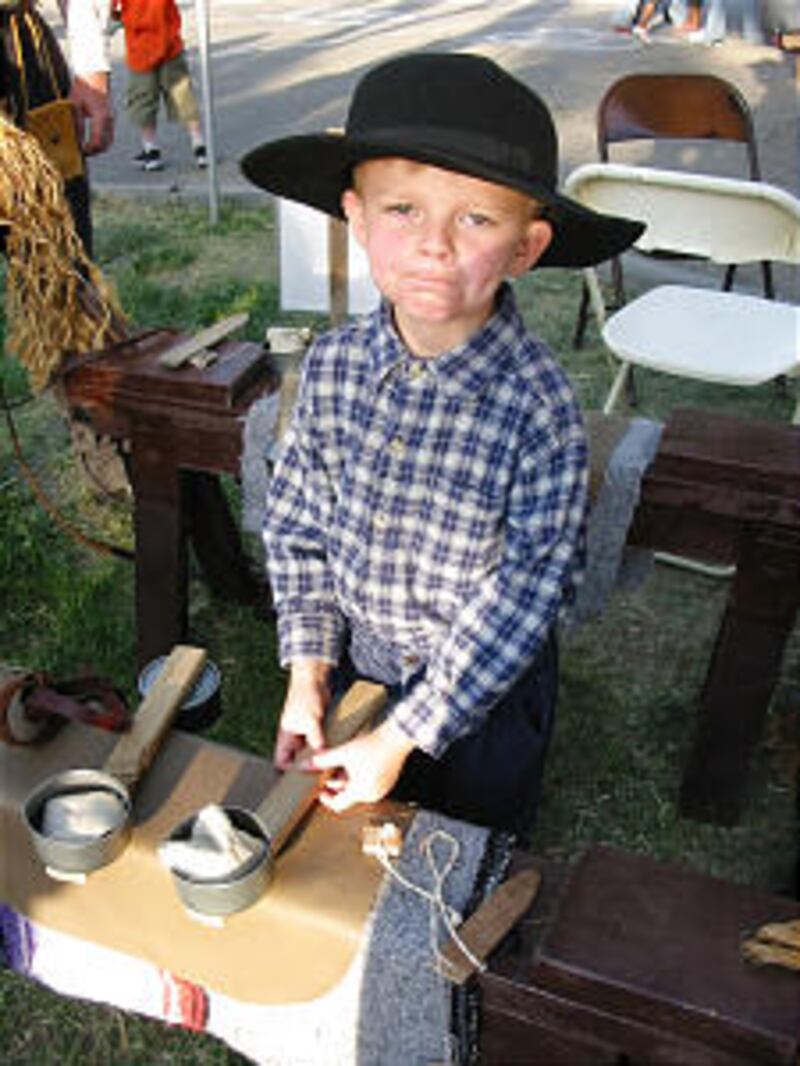 LDS boy waits to teach pioneer games to other children. Church members across the state re-enact his