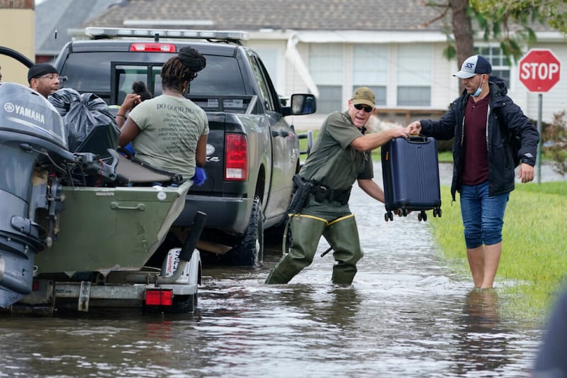Rescue personnel help residents of the Spring Meadow subdivision out of their flooded homes on a boat after Hurricane Ida moved through Monday, Aug. 30, 2021, in LaPlace, La. (AP Photo/Steve Helber)