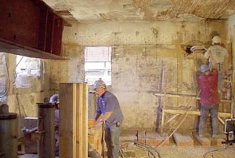 Months before the move, construction workers rig the academy building prior to lifting it off its fo