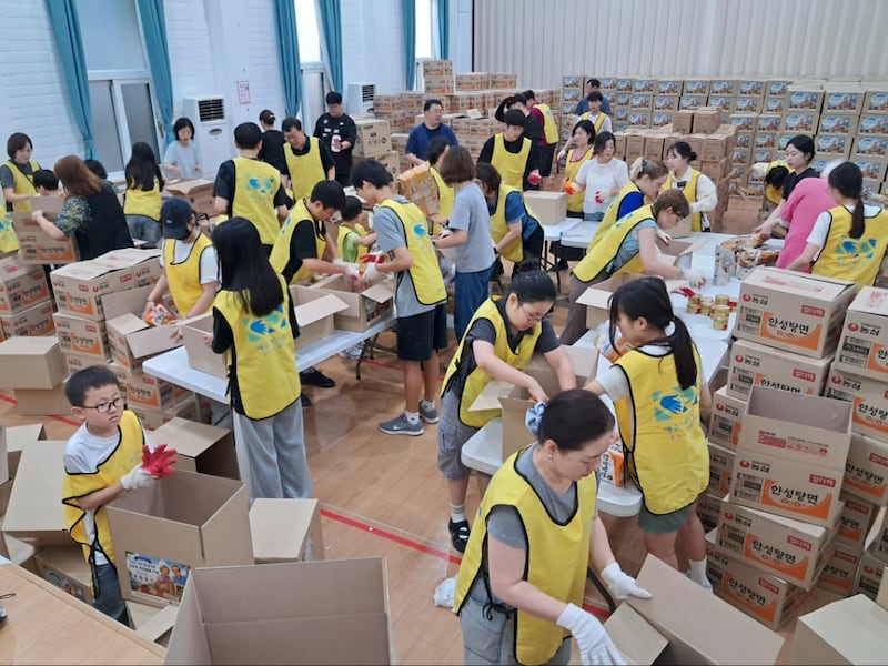 Members of the Busan Korea Stake package boxes for seniors in Busan, South Korea, on July 13, 2026.