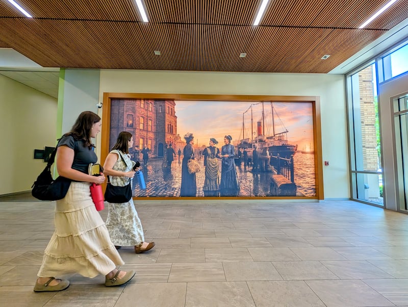 Sister missionaries at the Provo Missionary Training Center in Provo, Utah, walk past a new art installation featuring the first single sisters to serve as full-time missionaries.
