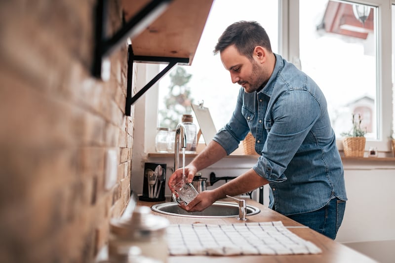 Young man washing the dishes.