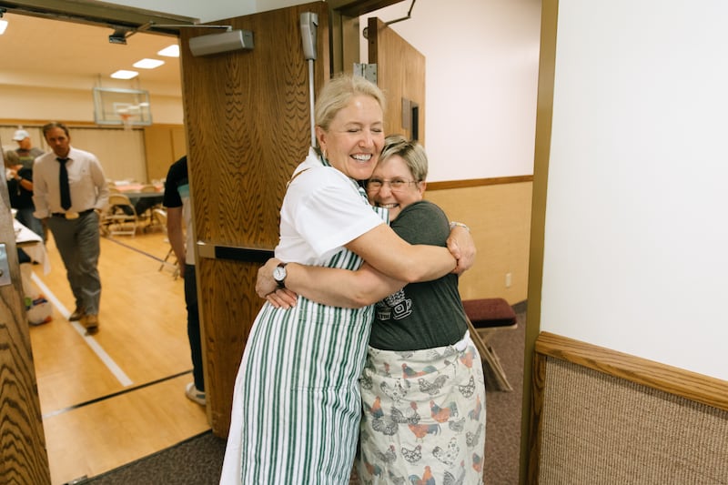 Church members embrace at a meetinghouse in Spokane while serving meals to evacuees on Sunday, Aug. 2, 2026.