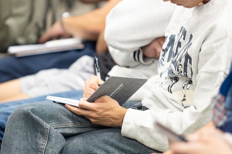 Students take notes as Deseret News publisher Burke Olsen speaks during an Ensign College devotional in Salt Lake City, Sept. 8, 2026.