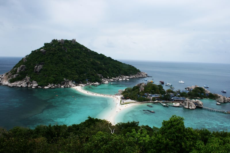 A scenic high angle view of tropical islands connected by a white sandbar in turquoise sea.