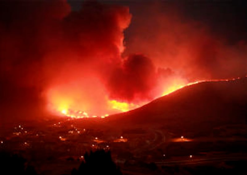 Flames from the wildfire light up the night sky above Herriman, Utah. The late-summer blaze was sta