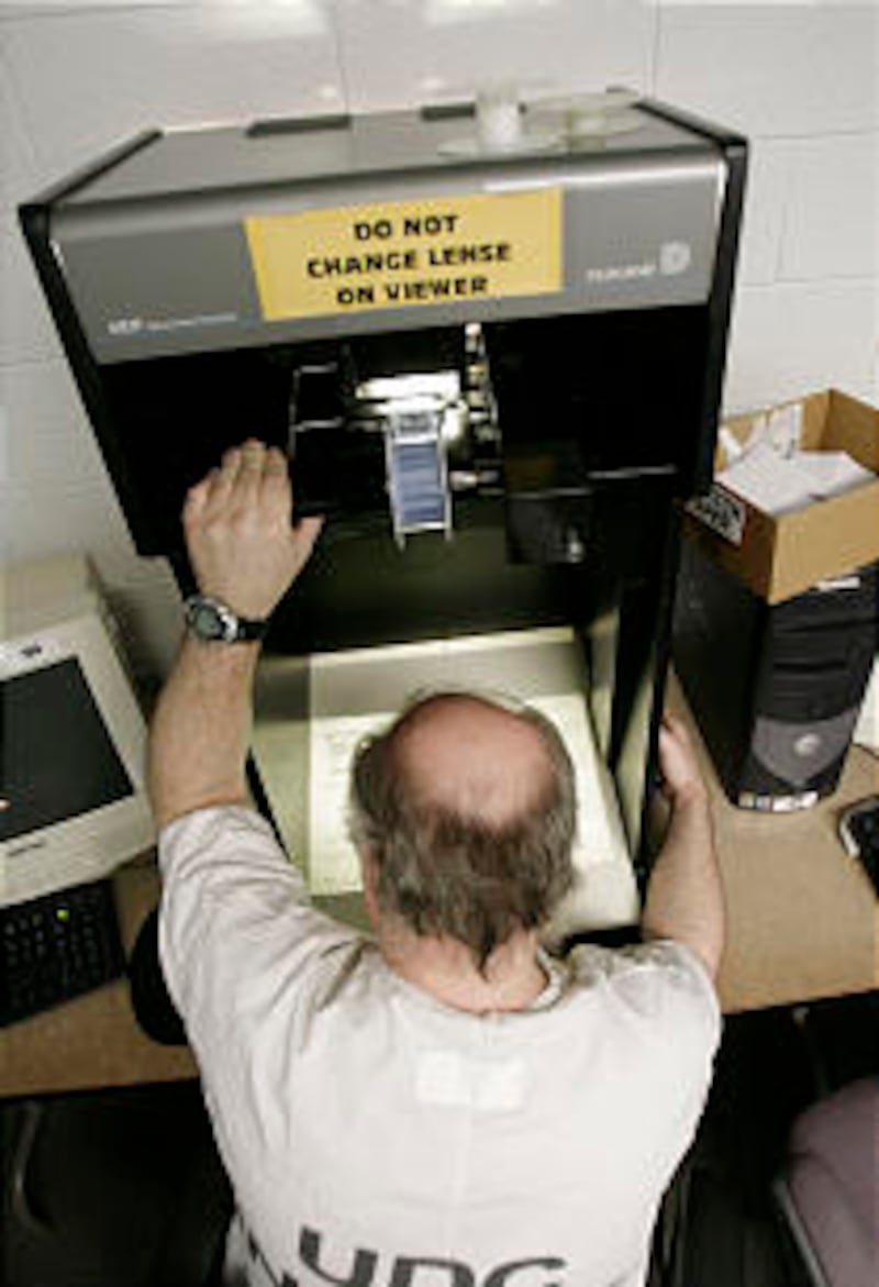 An inmate looks through microfilm to do family history work.
