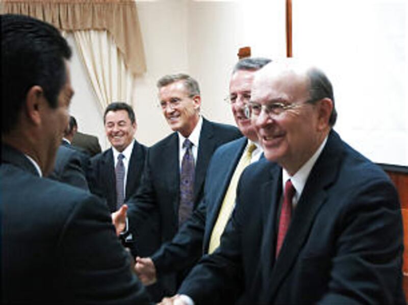 From right, Elder Quentin L. Cook, Elder Ulisses Soares and Elder Kevin R. Duncan shake hands with m