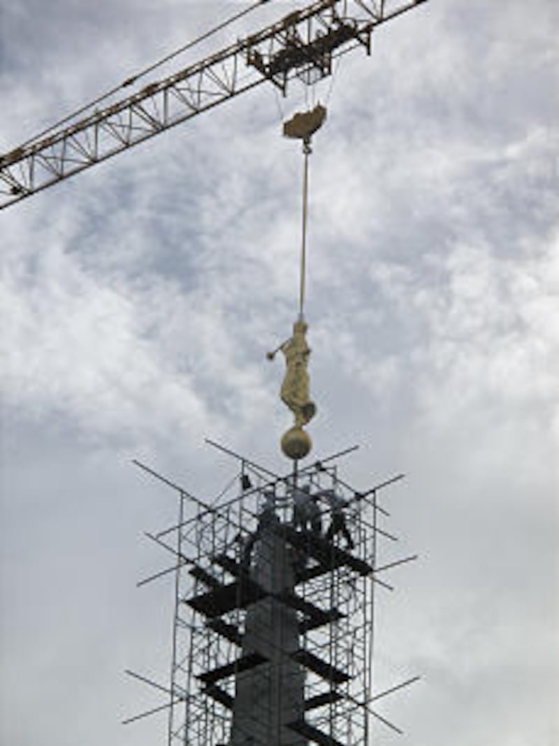 The statue of Moroni is hoisted high atop the Cebu Philippines Temple.