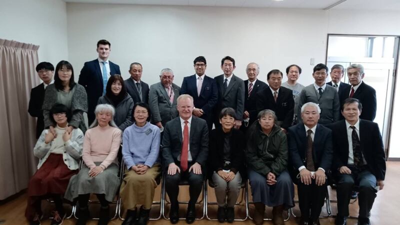 Elder J. Kimo Esplin and 22 others take a picture wearing suits, ties and dresses after sacrament meeting in Nanoa, Japan.