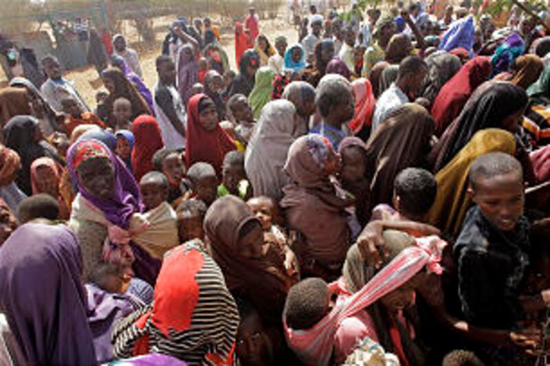 People wait outside a food distribution center to be registered as refugees in Dadaab, Kenya, on Aug