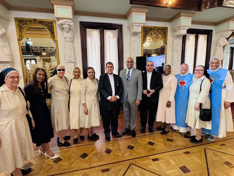 Elder Ahmad S. Corbitt, a General Authority Seventy and a member of the Caribbean Area presidency, stands in a gray suit with other religious leaders. He represented The Church of Jesus Christ of Latter-day Saints at a national day of prayer and thanksgiving interfaith event held Sept. 7, 2026, in the Hall of Caryatids at the National Palace in Santo Domingo, Dominican Republic.