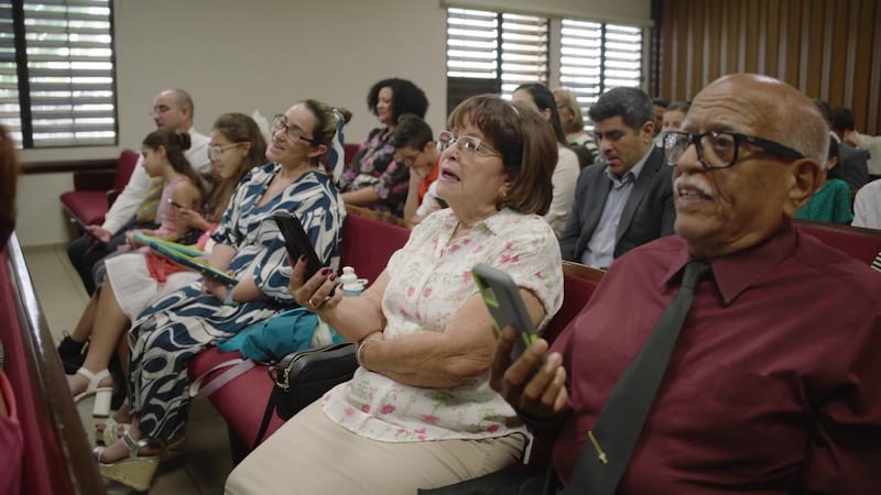 Church members in Puerto Rico sing using their phones during their sacrament meeting.