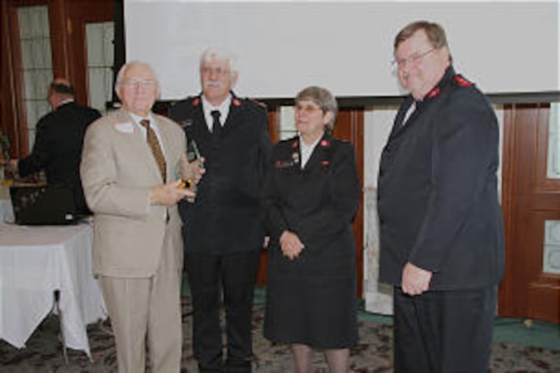 Elder Robert K. Dellenbach, far left, accepts award at May 8 Salvation Army luncheon from Major Rich