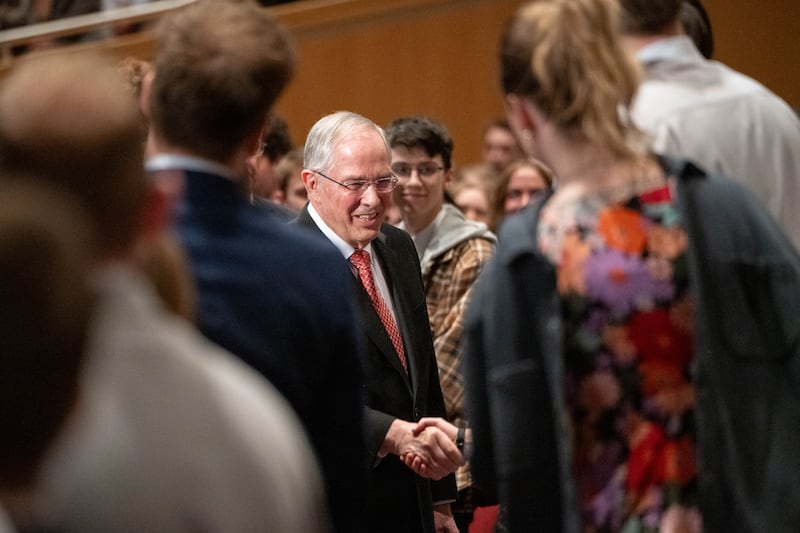 Elder Neil L. Andersen of the Quorum of the Twelve Apostles shakes hands with students gathered in the BYU–I Center during a devotional on Sunday, Feb. 22, 2026, in Rexburg, Idaho.