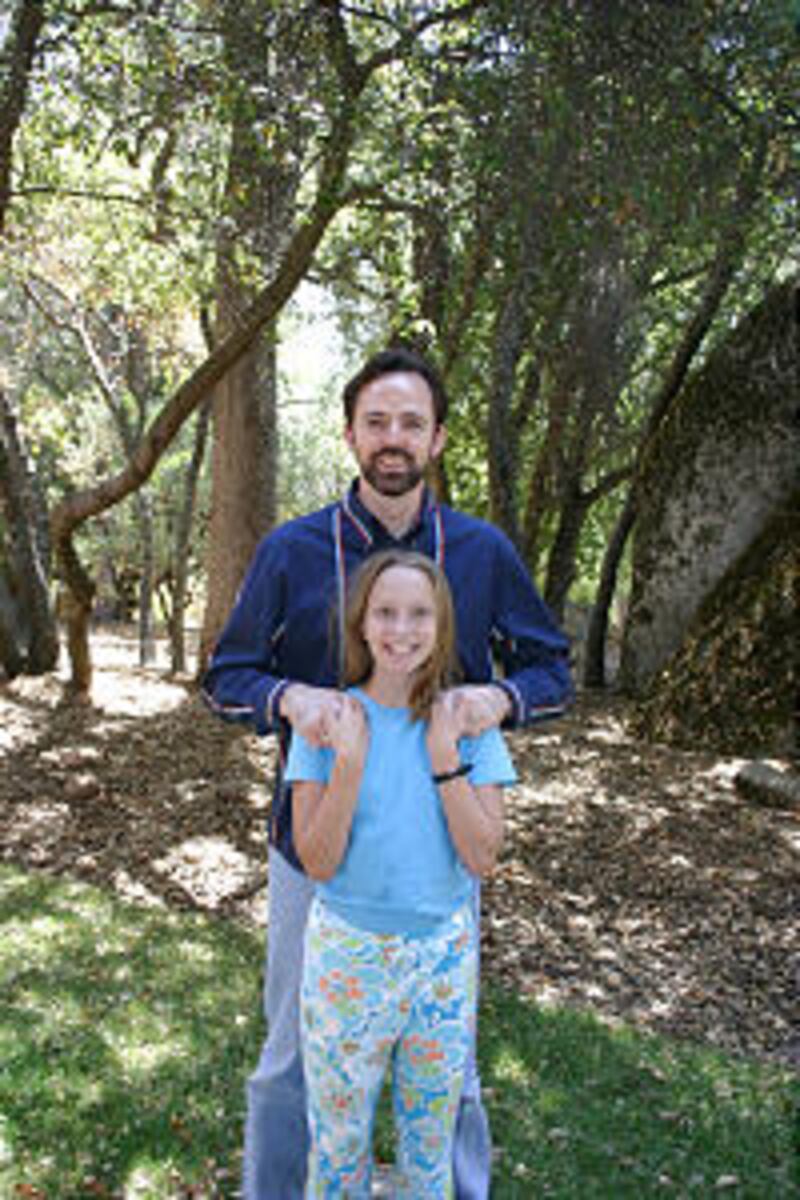 Chance Thomas and daughter, Tia, find joy in the wooded backyard of their mountain home. He is an aw