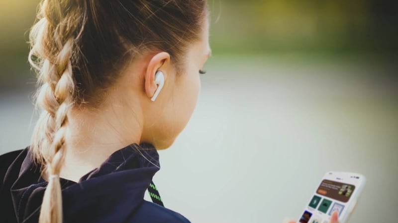 A woman uses headphones to listen to music. A new feature was added to the Gospel Library app in October 2025 that allows users to create and share playlists.