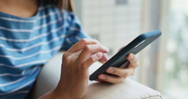 A woman looks at the Gospel Library app on her phone.