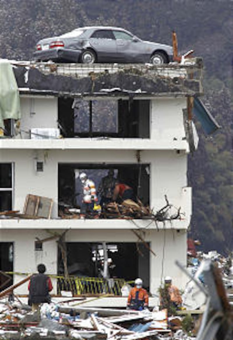 Firefighters search for missing people in Minamisanriku, northern Japan.