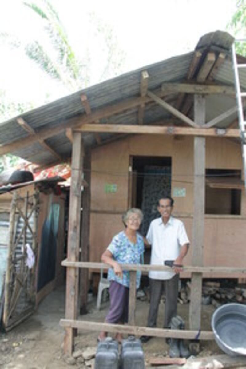 Editha Enghoy Malda and Dominador Mosca Malda stand in front of their new house in Taclaban, Philipp