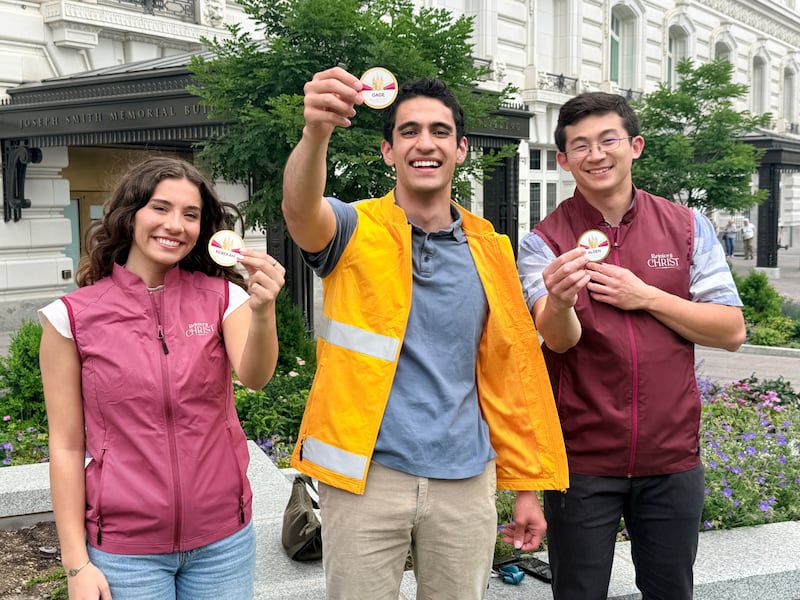 Volunteers display their name tags for the Salt Lake Temple Celebration in 2027.
