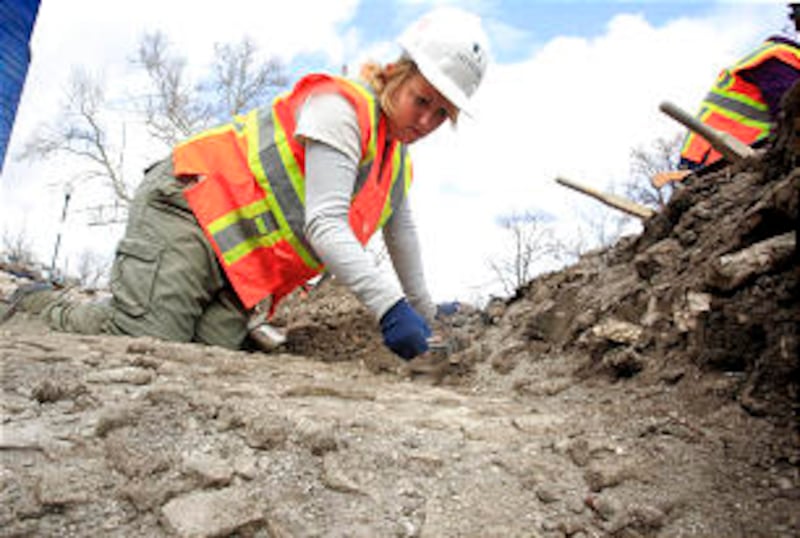 Katie Richards sifts through dirt at the excavation site for more clues describing the lives, work a