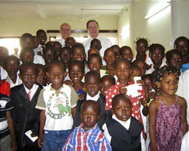 Elder Jeffrey R. Holland, at right on back row, and Elder L. Whitney Clayton pose for a photo with c