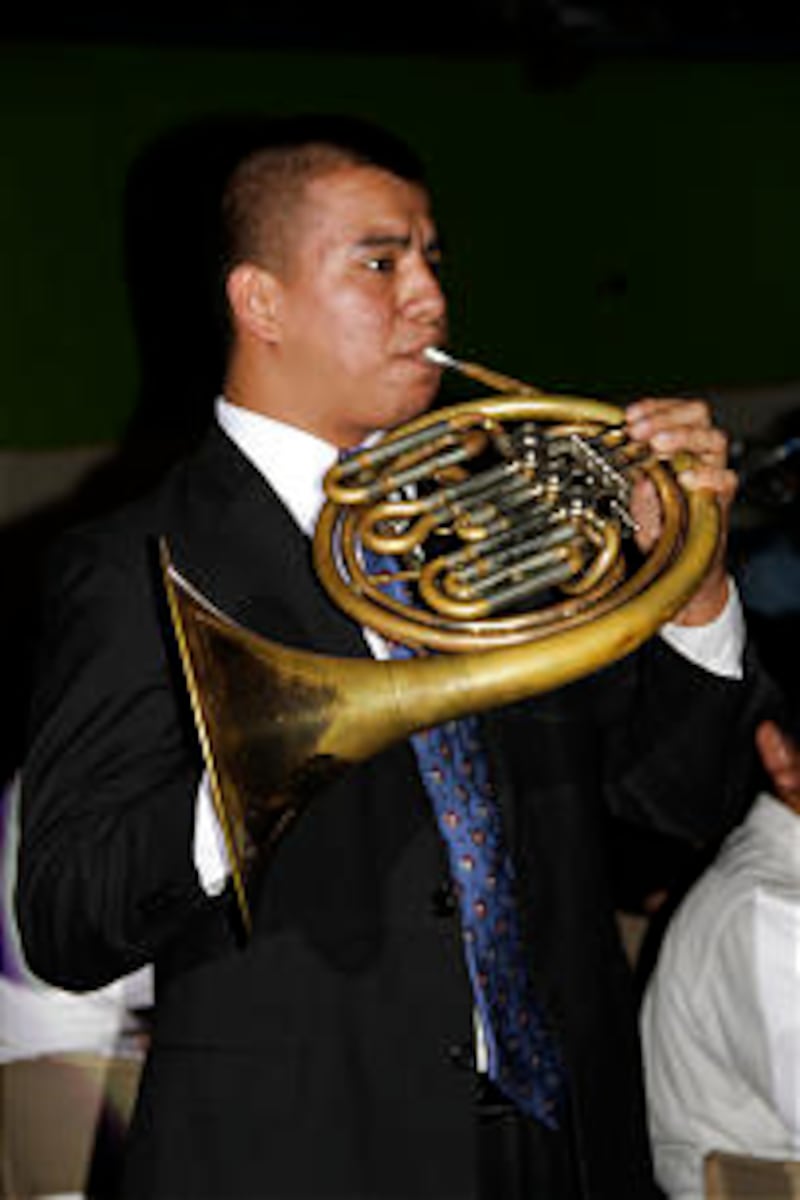 A young musician sounds the horn signaling the start of the Aug. 20 cultural celebration held at San